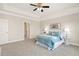Bedroom features a ceiling fan, tray ceilings, and plush carpet flooring at 405 Daisy Grove Ln, Holly Springs, NC 27540