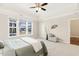 Spacious bedroom with tray ceilings, a ceiling fan, and large windows at 405 Daisy Grove Ln, Holly Springs, NC 27540