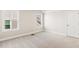 Bright, carpeted bedroom featuring two windows and neutral paint at 405 Daisy Grove Ln, Holly Springs, NC 27540
