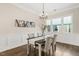 Elegant dining room featuring wainscoting, modern lighting, and views to the outside at 405 Daisy Grove Ln, Holly Springs, NC 27540
