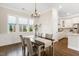 Bright dining room with chandelier lighting and sightlines into the kitchen, creating a comfortable dining experience at 405 Daisy Grove Ln, Holly Springs, NC 27540