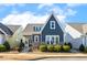 Charming house exterior with stone accents, covered porch, and neatly trimmed landscaping at 405 Daisy Grove Ln, Holly Springs, NC 27540