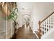 Warm foyer featuring hardwood floors, a staircase with white railings, and a view into the living area at 405 Daisy Grove Ln, Holly Springs, NC 27540