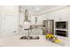 A well-lit kitchen boasts white cabinets, stainless steel appliances, and a spacious island with a modern faucet at 405 Daisy Grove Ln, Holly Springs, NC 27540