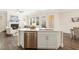 Kitchen island with stainless steel dishwasher blends seamlessly with living and dining areas for easy conversation at 405 Daisy Grove Ln, Holly Springs, NC 27540