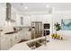 Bright kitchen featuring stainless steel appliances, white cabinets and countertops, and a convenient island with a sink at 405 Daisy Grove Ln, Holly Springs, NC 27540