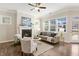Inviting living room with a fireplace, hardwood floors, and abundant natural light, perfect for relaxation at 405 Daisy Grove Ln, Holly Springs, NC 27540