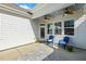 Inviting covered patio with two blue chairs, ceiling fans, and stone pavers at 405 Daisy Grove Ln, Holly Springs, NC 27540