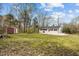 Home's backyard with a fire pit, shed, and grassy area with mature trees at 4509 Alamance Baptist Church Loop, Burlington, NC 27215