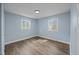 Bedroom with wood-look flooring, two bright windows, and neutral paint at 4509 Alamance Baptist Church Loop, Burlington, NC 27215