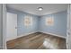 Corner bedroom showcasing hardwood flooring, two bright windows, and neutral paint at 4509 Alamance Baptist Church Loop, Burlington, NC 27215