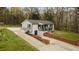 Beautifully renovated exterior of home featuring a brick retaining wall and covered front porch at 4509 Alamance Baptist Church Loop, Burlington, NC 27215