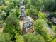 An aerial view of a new construction home surrounded by tall trees on a muddy lot at 5107 Hearth Dr, Raleigh, NC 27609