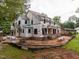 New construction two-story home with a brick base, black framed windows, and ladder access points surrounded by raw land at 5107 Hearth Dr, Raleigh, NC 27609