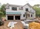 New construction home with a two-car garage that has a blue covering on the roof on a gravel lot at 5107 Hearth Dr, Raleigh, NC 27609