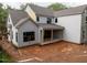 A new construction home with a covered back patio that has exposed wood support beams on a muddy lot at 5107 Hearth Dr, Raleigh, NC 27609