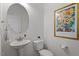 Small bathroom features a toilet, sink, decorative items, and a sunflower painting at 5205 Sorrell Glen Dr, Raleigh, NC 27603