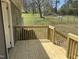 New wooden deck with views of a grassy backyard with trees, with wooden railing at 5486 B Us Hwy 301, Four Oaks, NC 27524