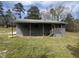 Gray home featuring covered porch with wood posts and railing, steps, and yard at 5486 B Us Hwy 301, Four Oaks, NC 27524