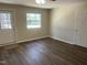 Living room with new floors, exterior door, and access to another room at 5486 B Us Hwy 301, Four Oaks, NC 27524