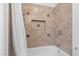 Bathtub and shower combination with tiled walls and recessed shelving offer a functional design at 55 Lindsey St, Pittsboro, NC 27312