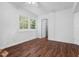 White bedroom with hardwood floors, white trim, and a window view into the trees outside at 55 Lindsey St, Pittsboro, NC 27312