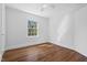 Bright bedroom with hardwood floors, a ceiling fan, and a large window offering plenty of natural light at 55 Lindsey St, Pittsboro, NC 27312