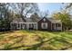Charming single-story home with a well-manicured lawn, pergola, and inviting front porch at 55 Lindsey St, Pittsboro, NC 27312