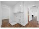 Hallway with laundry hookups and white cabinets for storage and hardwood flooring throughout the house at 55 Lindsey St, Pittsboro, NC 27312