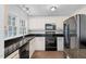 Well-lit kitchen with modern appliances, granite countertops and a double sink at 55 Lindsey St, Pittsboro, NC 27312
