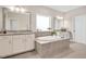 Luxurious bathroom featuring an oval tub, granite countertops, and dual sinks at 715 White Oak Pond Rd, Apex, NC 27523