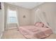 Bedroom featuring a pink bed with canopy, a window with sheer curtains, and carpeted floors at 715 White Oak Pond Rd, Apex, NC 27523