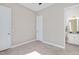 Neutral bedroom with carpeted floors, a ceiling fan, and an open doorway to the ensuite bathroom at 715 White Oak Pond Rd, Apex, NC 27523