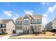 Charming gray two-story home with stone accents, covered porch, manicured lawn and attached two-car garage at 715 White Oak Pond Rd, Apex, NC 27523