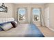 Bright bedroom featuring a white bed frame, blue bedding, and natural light from windows at 715 White Oak Pond Rd, Apex, NC 27523