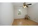 Minimalist bedroom with hardwood floors, ceiling fan, and natural light from the window at 716 Red Forest Trl, Raleigh, NC 27615