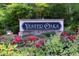 Community entrance sign surrounded by colorful flower bushes and greenery at 716 Red Forest Trl, Raleigh, NC 27615