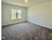 Bright, carpeted bedroom with a window overlooking the yard offers a relaxing retreat at 75 Furley St., Homesite 115, Sanford, NC 27330