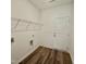 Functional laundry area equipped with shelving and wood-look flooring provides a clean, organized space at 75 Furley St., Homesite 115, Sanford, NC 27330