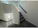 Carpeted staircase with wood railing and bright natural light at 75 Furley St., Homesite 115, Sanford, NC 27330