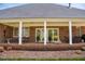 Back porch with white columns, brick flooring, outdoor seating, and ceiling fans at 805 Lee St, Gibsonville, NC 27249