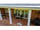 Covered brick patio with white columns, French doors and greenery in planters at 805 Lee St, Gibsonville, NC 27249