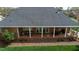 Aerial view of brick back porch with white columns; part of a lush lawn at 805 Lee St, Gibsonville, NC 27249