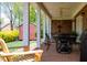 Covered brick back porch with white columns and black metal furniture at 805 Lee St, Gibsonville, NC 27249