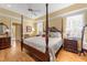 Spacious main bedroom boasts a four-poster bed, hardwood floors, and great natural lighting at 805 Lee St, Gibsonville, NC 27249