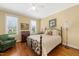 Cozy bedroom with hardwood floors, a wrought iron bed frame, and an armchair at 805 Lee St, Gibsonville, NC 27249