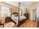 The primary bedroom has a tray ceiling and a four-poster bed, with great natural light at 805 Lee St, Gibsonville, NC 27249