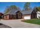 Brick home with a spacious driveway and an attached garage, showcasing the well-maintained landscape at 805 Lee St, Gibsonville, NC 27249