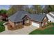 Attractive brick home with a well-manicured lawn, paved driveway and attached two-car garage at 805 Lee St, Gibsonville, NC 27249