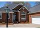 Detailed close-up of brick home's entry with an arched window and manicured landscaping at 805 Lee St, Gibsonville, NC 27249
